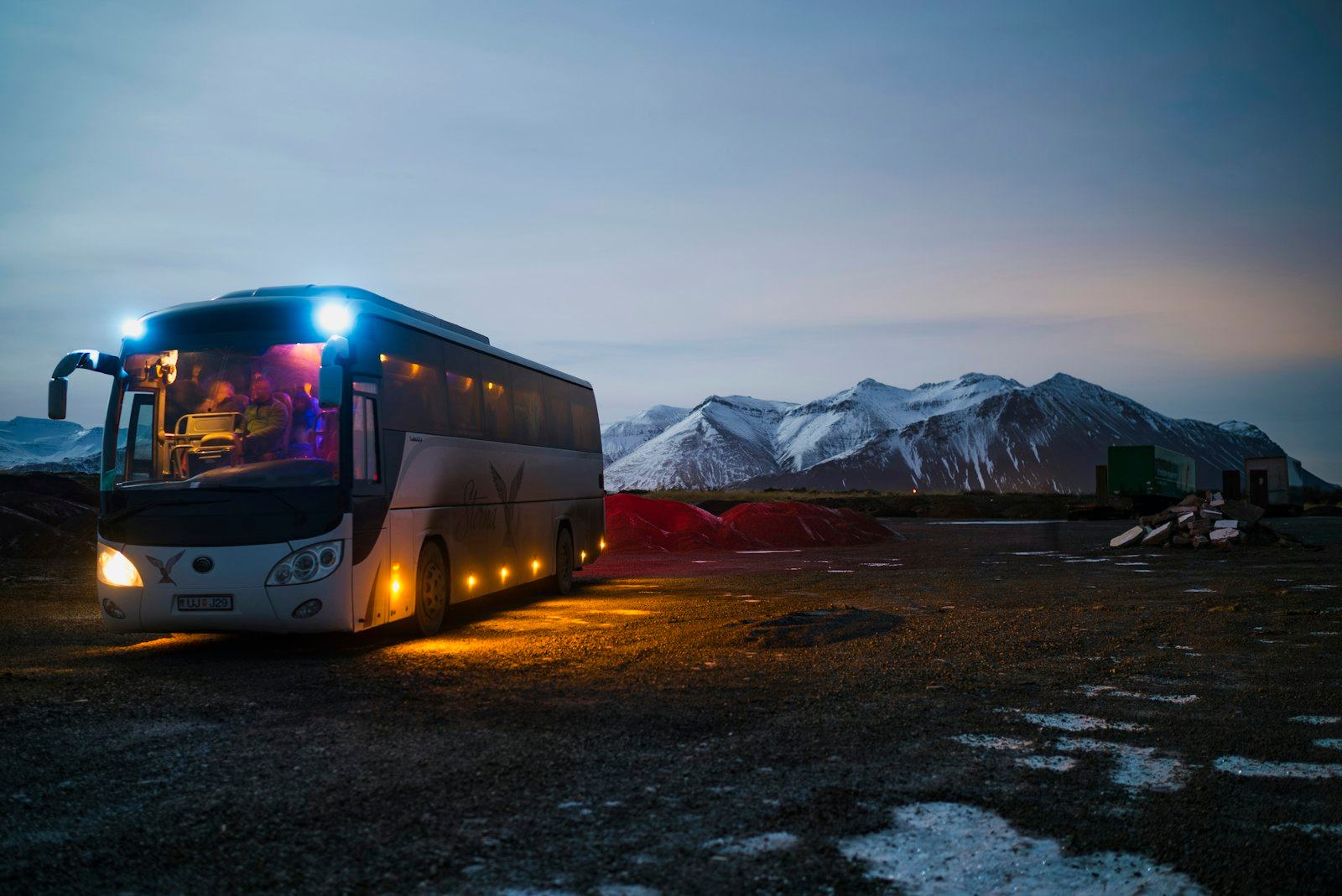 Coach bus travelling a mountain road, illustrating ground transport for a delegate group