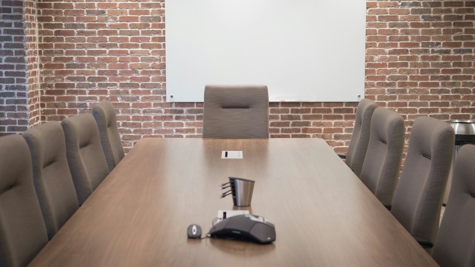 Conference room set with a projector screen and rows of chairs, the format day delegate rates are quoted against