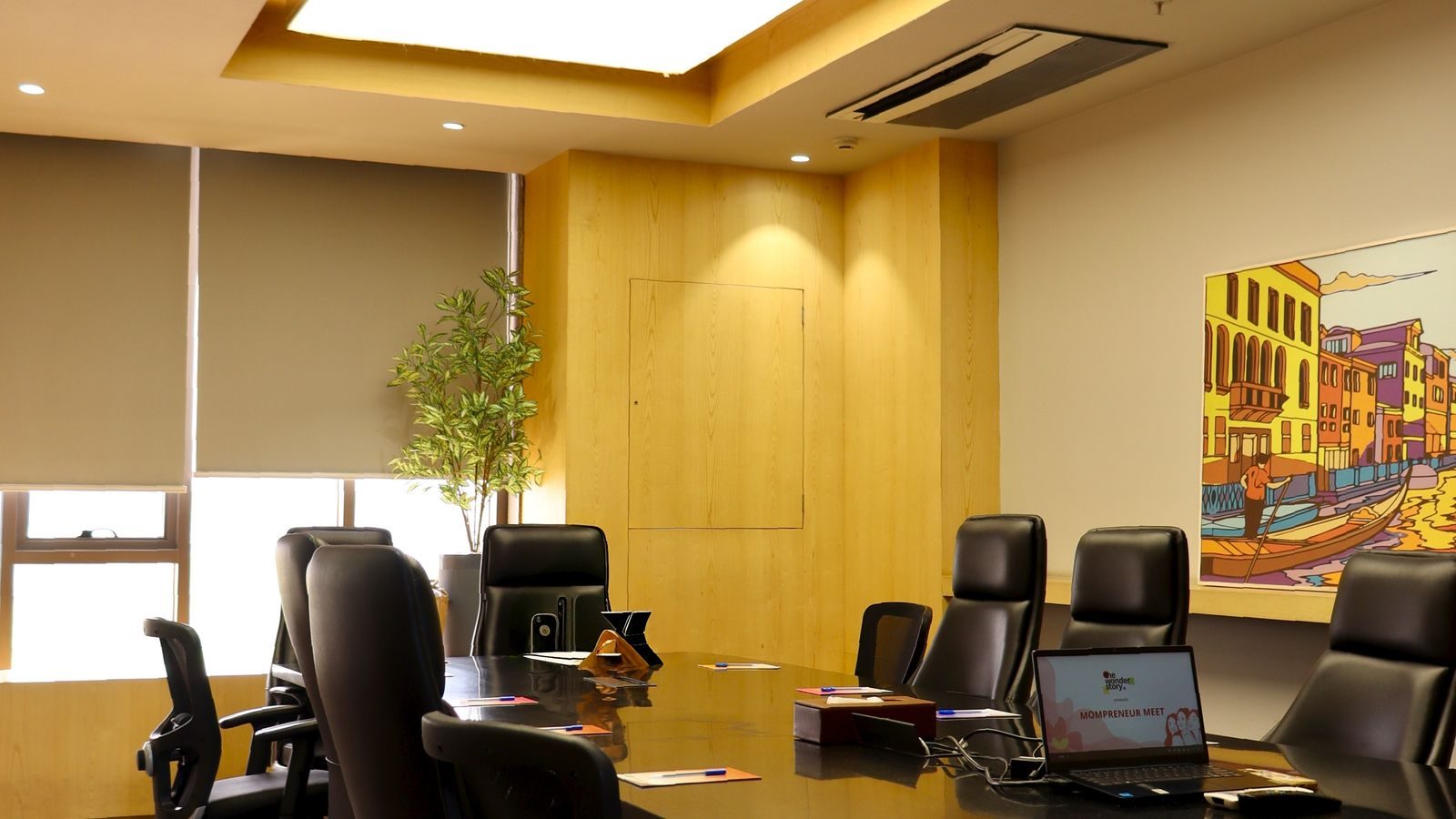 Modern boardroom with a long table and ergonomic chairs beside a window