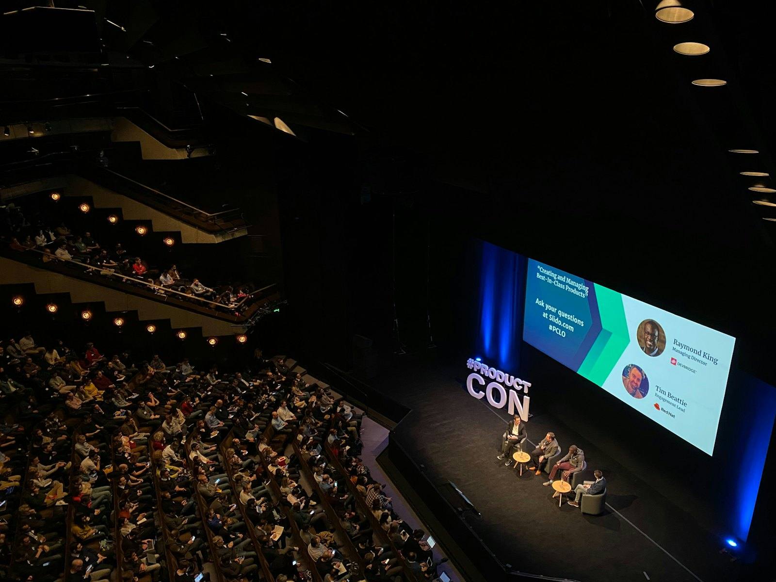Delegates seated in a conference auditorium during a panel session at a corporate event