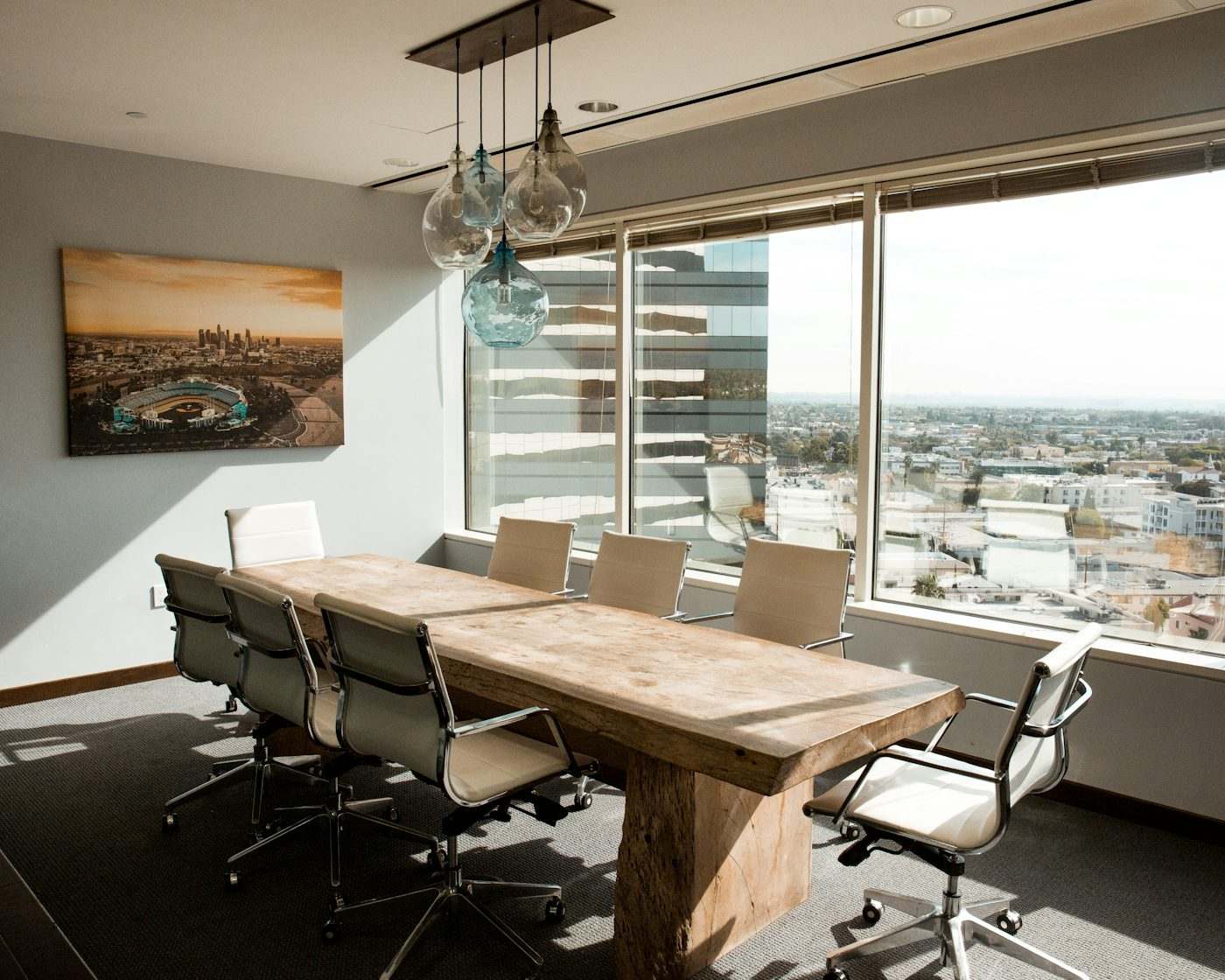 Boardroom-style meeting table set for a small corporate group, the format replacing the 100-person plenary