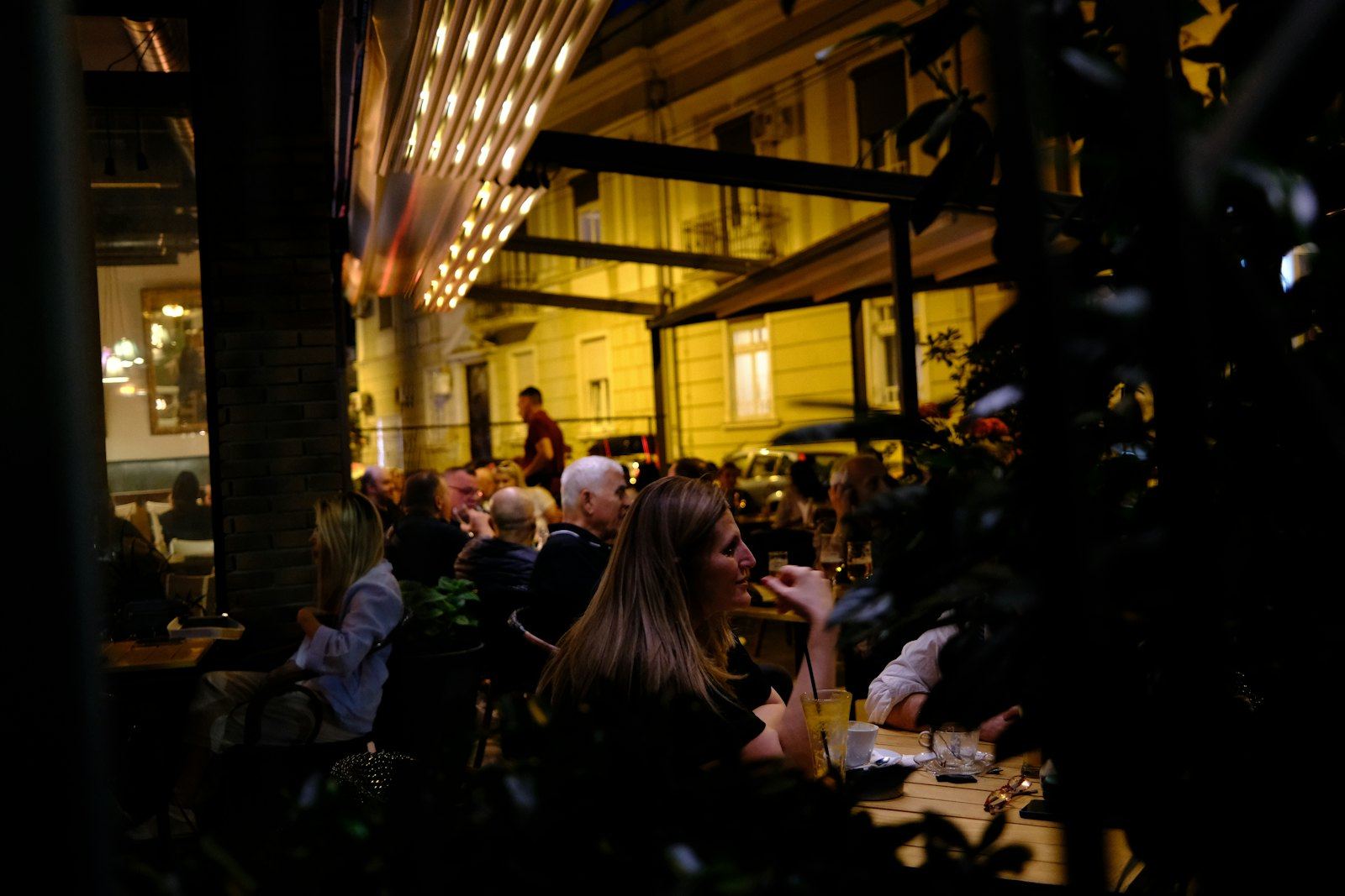 Small group dinner at a long table on a terrace at dusk, the kind of evening a 35-person budget can afford