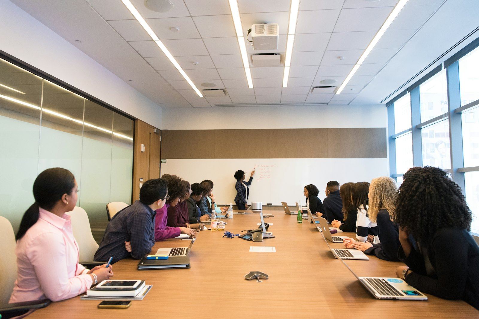 Small corporate meeting of around a dozen people around one conference table, the 2026 format