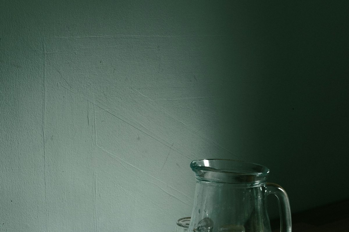 Glass water pitchers on a wooden service counter as reusable event water service